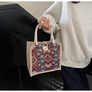 Detail of tribal pattern weaving and white rope handle on ethnic tote bag