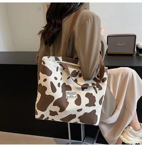 Detail of the corduroy tote bag featuring a cow print design and soft fabric texture