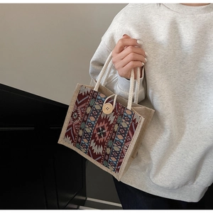 Detail of multi-color geometric weaving pattern and wooden button closure on tote bag