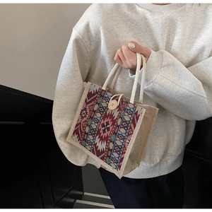 Detailed close-up of ethnic patterned handbag with woven texture and wooden button closure