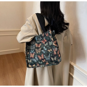 Detail of large tote bag showing vintage butterfly prints and black shoulder strap