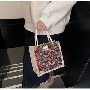 Detailed shot of ethnic woven jute handbag with geometric patterns and a wooden button closure