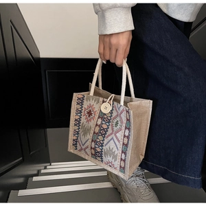 Close-up of ethnic woven pattern and jute fiber texture on a stylish square handbag