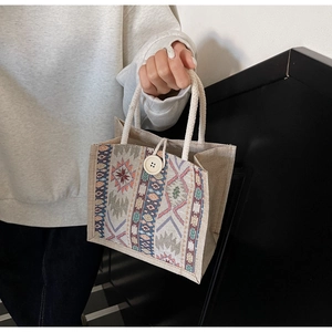 Detail of bohemian woven handbag with cotton rope handles and large decorative button