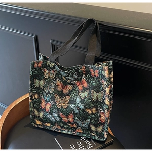 Detailed close-up of intricate butterfly embroidery on this large vintage tote bag