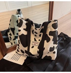 Detail of black and white cow print tote bag made of textured corduroy fabric material