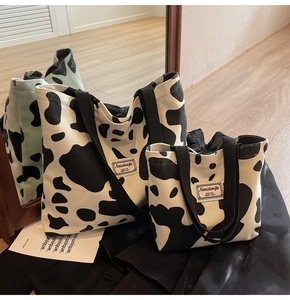 Detailed macro shot of cow print corduroy tote bag set with black canvas handles