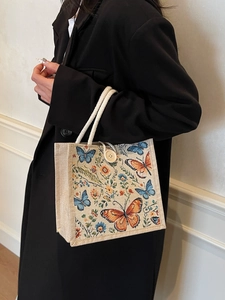 Linen tote bag with butterfly embroidery and rope handle shown in a street style view