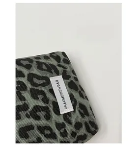 Close-up of leopard print canvas bag featuring a rectangular woven brand tag design