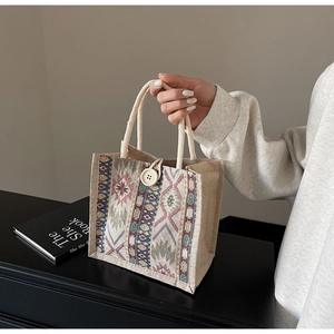 Detail of ethnic geometric pattern woven tote bag with rope handle and button closure