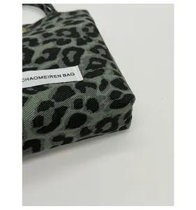Detailed close-up of durable leopard print fabric and stitching on a small shoulder bag