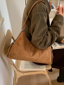Sac hobo en daim marron avec bandoulière en cuir lisse dans un décor de style de vie chic