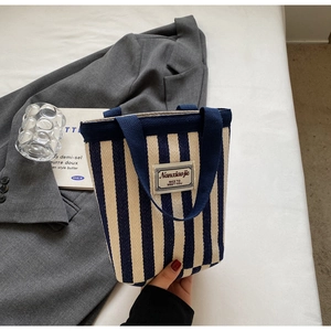 Close-up of blue and white striped canvas tote bag with Nanxiaojie woven label detail