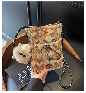 Détail du sac de téléphone bohème avec motif tricot géométrique et pompon duveteux
