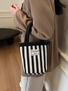 Minimalist striped canvas handbag for women with black and white vertical patterns