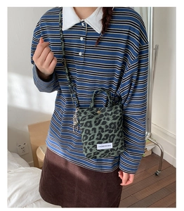 Detail view of leopard print small crossbody bag with adjustable strap and top handle