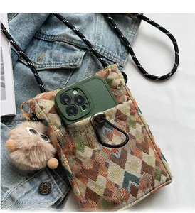 Detail of bohemian woven crossbody bag with phone pocket and decorative plush charm