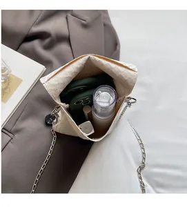Top view of woven crossbody bag interior showing storage space for phone and lipstick