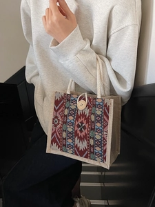 Bohemian style jute tote bag with colorful geometric patterns and rope handles