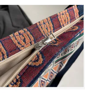 Detail of smooth silver zipper on ethnic geometric pattern woven canvas bucket bag