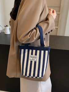 Blue and white striped canvas bucket bag with navy blue top handles for daily casual use