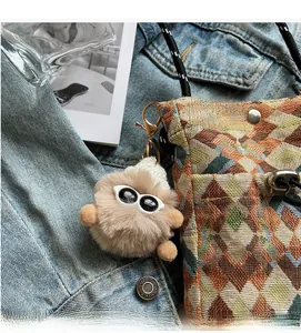 Close-up of plush charm with sunglasses and knit hat on a quilted crossbody bag