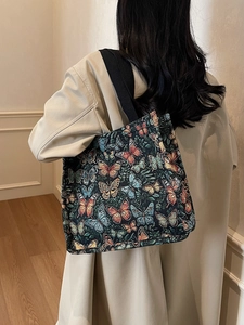 Large butterfly jacquard tote bag with black wide straps shown on a model for daily use