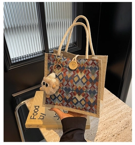 Detail of woven patterns and wooden button closure on a vintage style linen handbag