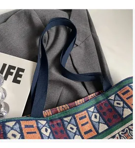 Detail of the sturdy woven handles and ethnic geometric pattern on the canvas tote bag