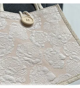Close-up of floral jacquard tote bag with wooden button and woven rope handle