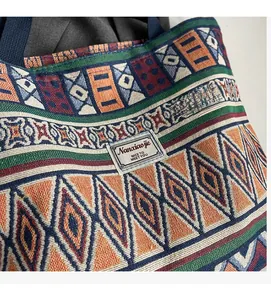Detailed close-up of ethnic woven bucket bag with geometric patterns and brand label