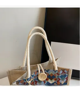 Detailed view of ethnic knit tote bag with braided rope handles and wood button closure