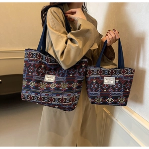 Detail of canvas bucket bag set with ethnic geometric patterns and wide woven handles