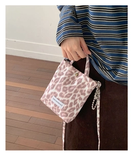 Detail of pink leopard canvas bag featuring metal snap button and decorative chain
