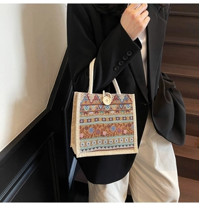 Detailed close-up of ethnic woven jute handbag with colorful geometric patterns and wood buckle