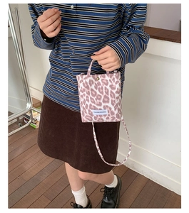 Close-up of leopard print canvas mini tote bag with branding and thin shoulder strap
