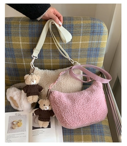 Détail de sacs demi-lune en polaire pelucheuse crème et rose avec breloque ours