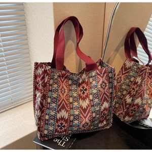 Macro detail of ethnic geometric jacquard fabric on a large capacity red tote bag