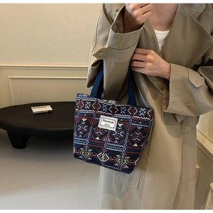 Close-up of ethnic geometric woven fabric and branded cloth label on large canvas tote bag