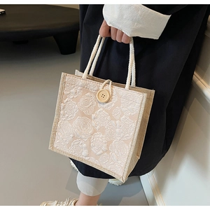 Close-up of floral linen tote bag featuring cotton rope handles and a large wooden button