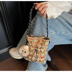 Détail du sac bandoulière bohème en toile à damier avec breloque en peluche pour femme