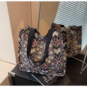 Detail of bohemian tote bag with colorful geometric woven pattern and wide black straps