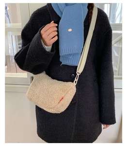 Détail d'un sac bandoulière en polaire crème avec large sangle porté par un mannequin
