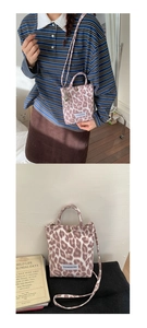 Detail of pink leopard print canvas bag showing texture, woven label, and shoulder strap