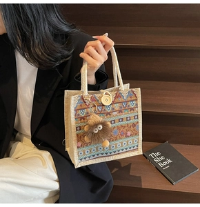 Detail of bohemian tote bag with ethnic patterns, rope handles and plush charm