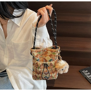 Détail du sac de téléphone bohème en toile avec motifs géométriques colorés et breloque