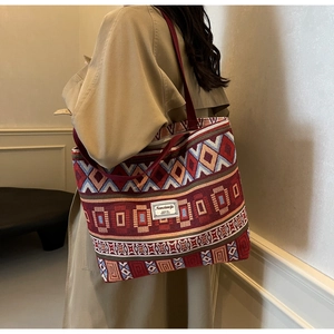 Detail of vintage geometric jacquard pattern and woven strap on a canvas bucket bag