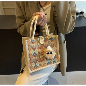 Close-up of diamond pattern linen handbag with cotton rope handle and plush charm detail