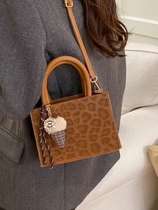 Fashionable leopard print tote bag with plush ice cream charm and adjustable shoulder strap