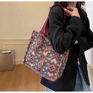Ethnic tote bag with geometric patterns shown on a model in a stylish interior